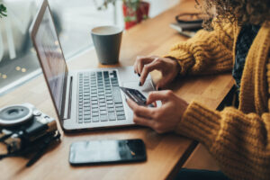 woman with card, phone and laptop.