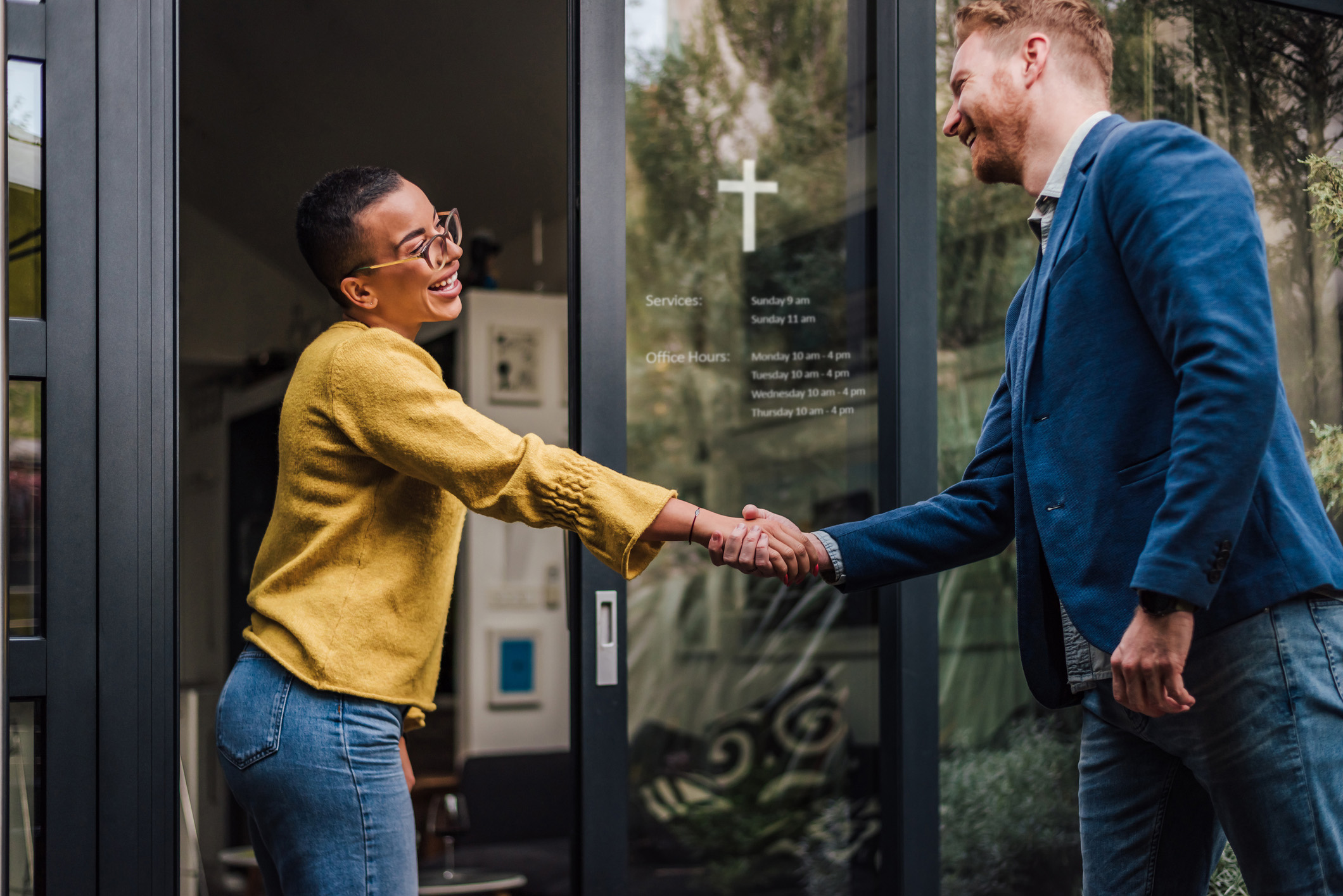 Twp people shaking hand outside a church door.